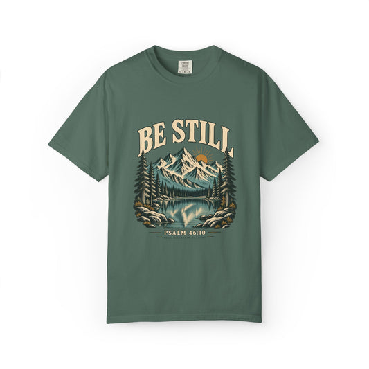 Blue Spruce Comfort Colors 1717 T-shirt with Be Still mountain, lake, pine trees, and Psalm 46:10 front graphic.