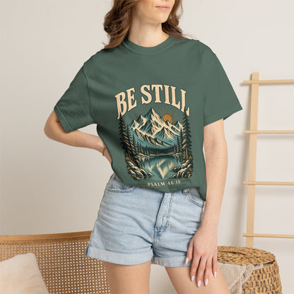 Female model wearing the Blue Spruce Be Still Christian mountain T-shirt with denim shorts.