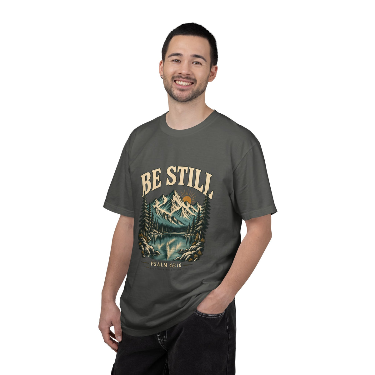 Male model wearing the Pepper Be Still Christian mountain T-shirt, showing the relaxed unisex fit.
