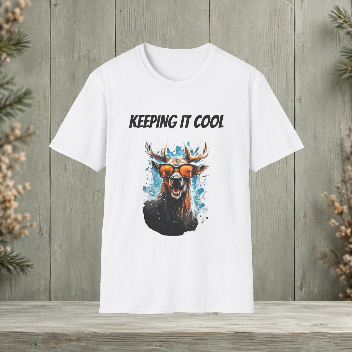 White Keeping It Cool T-Shirt front view with original antler artwork on a muted woodland background.