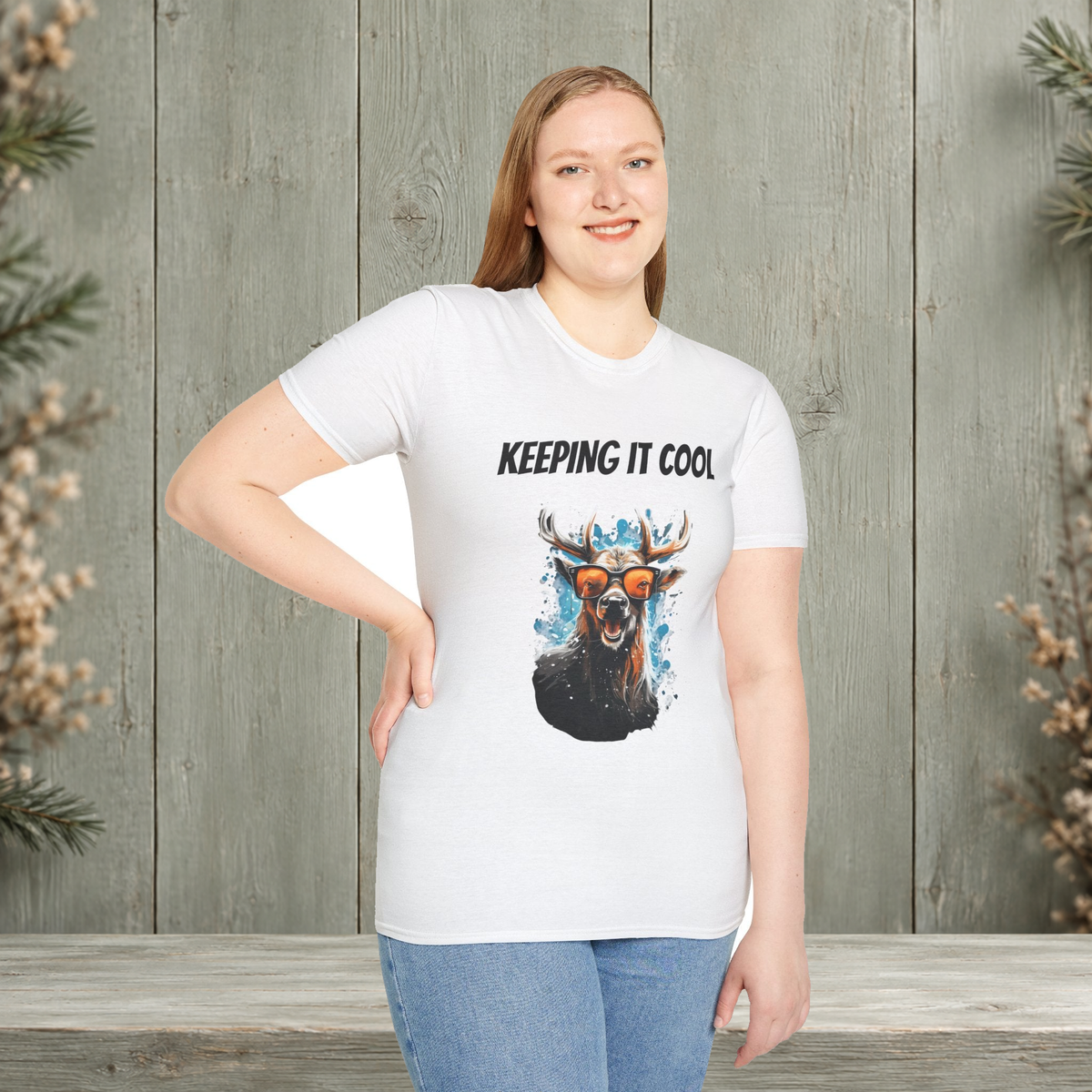 Woman wearing the white Keeping It Cool T-Shirt with original antler artwork on a muted woodland background.